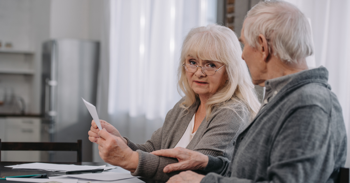 Senior couple reviewing documents together while discussing their legacy planning and estate paperwork at home