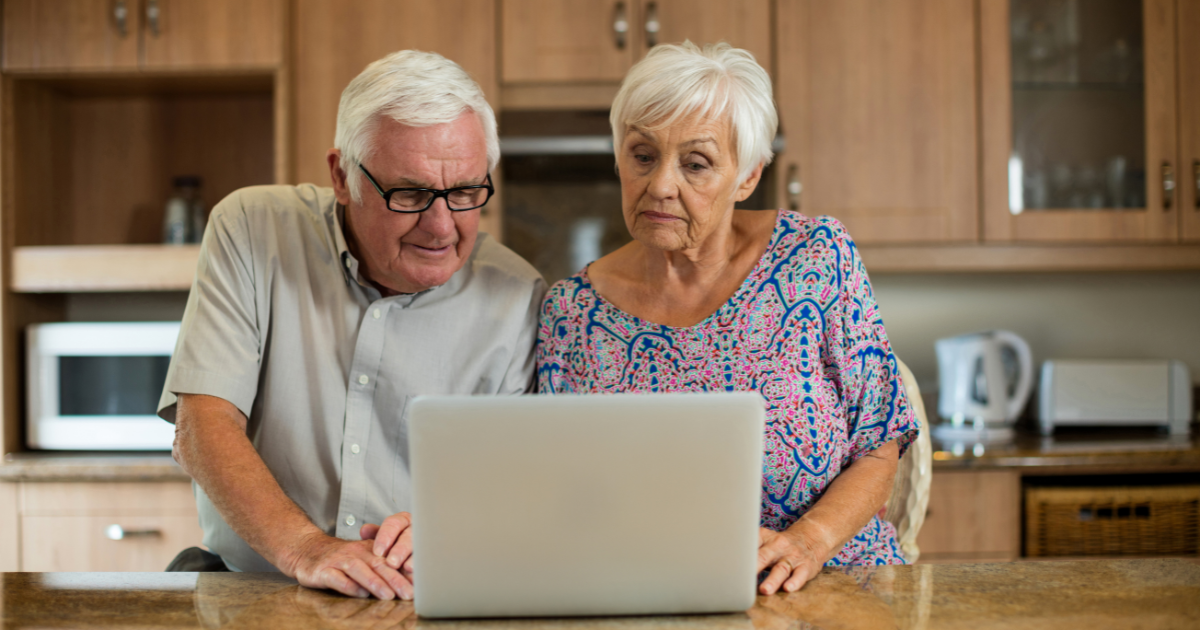 Older couple at home checking how AI stocks affect their retirement investments