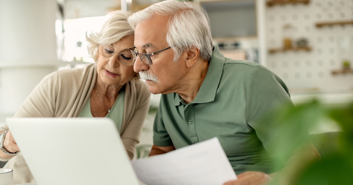 Retired couple reviewing retirement budget and financial documents at home